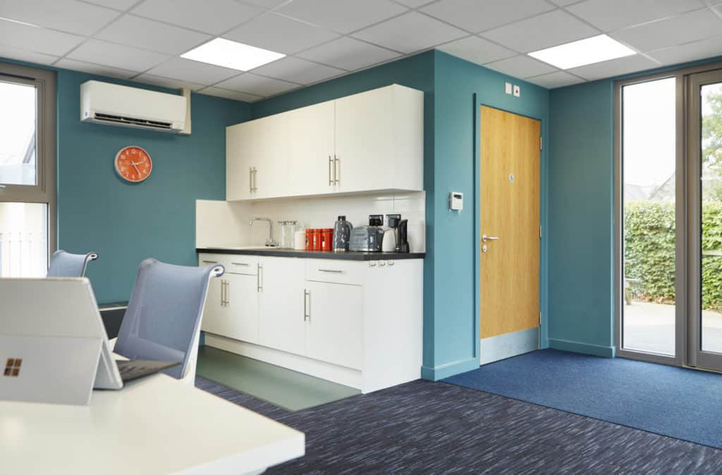Inside modular education building. Office space. Kitchen area for staff.